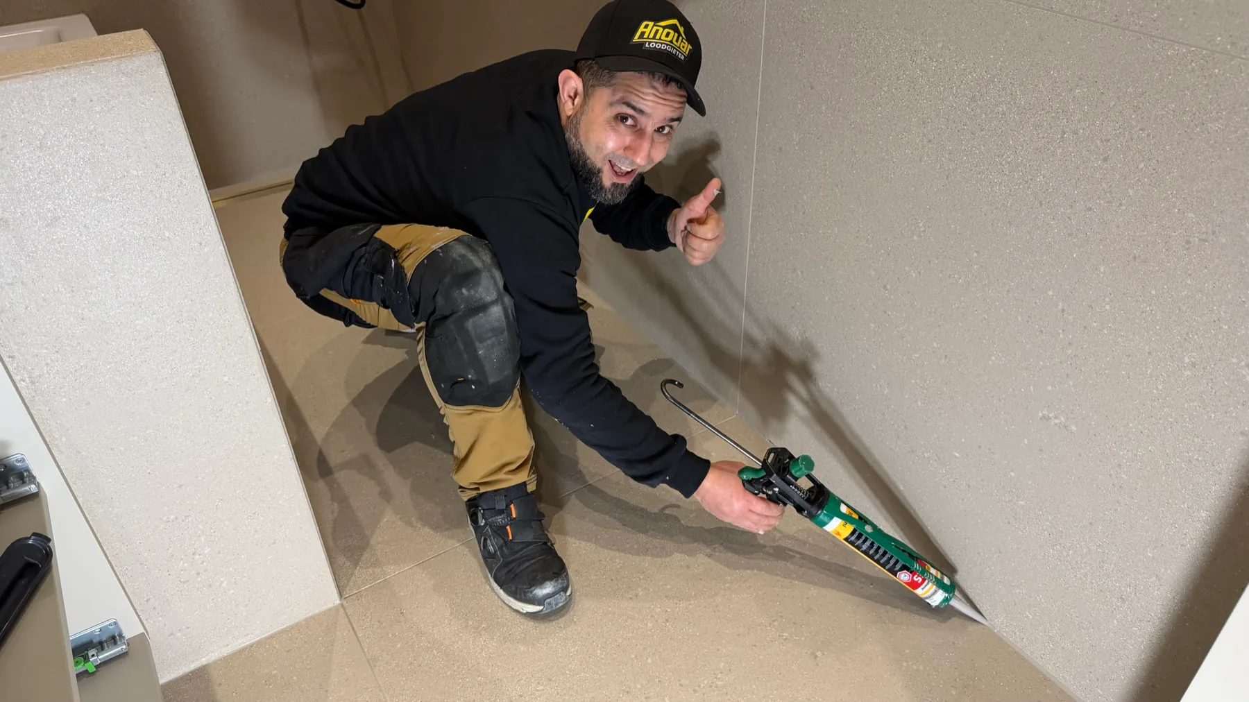 Anouar van ANO brengt een kitnaad aan in een badkamer