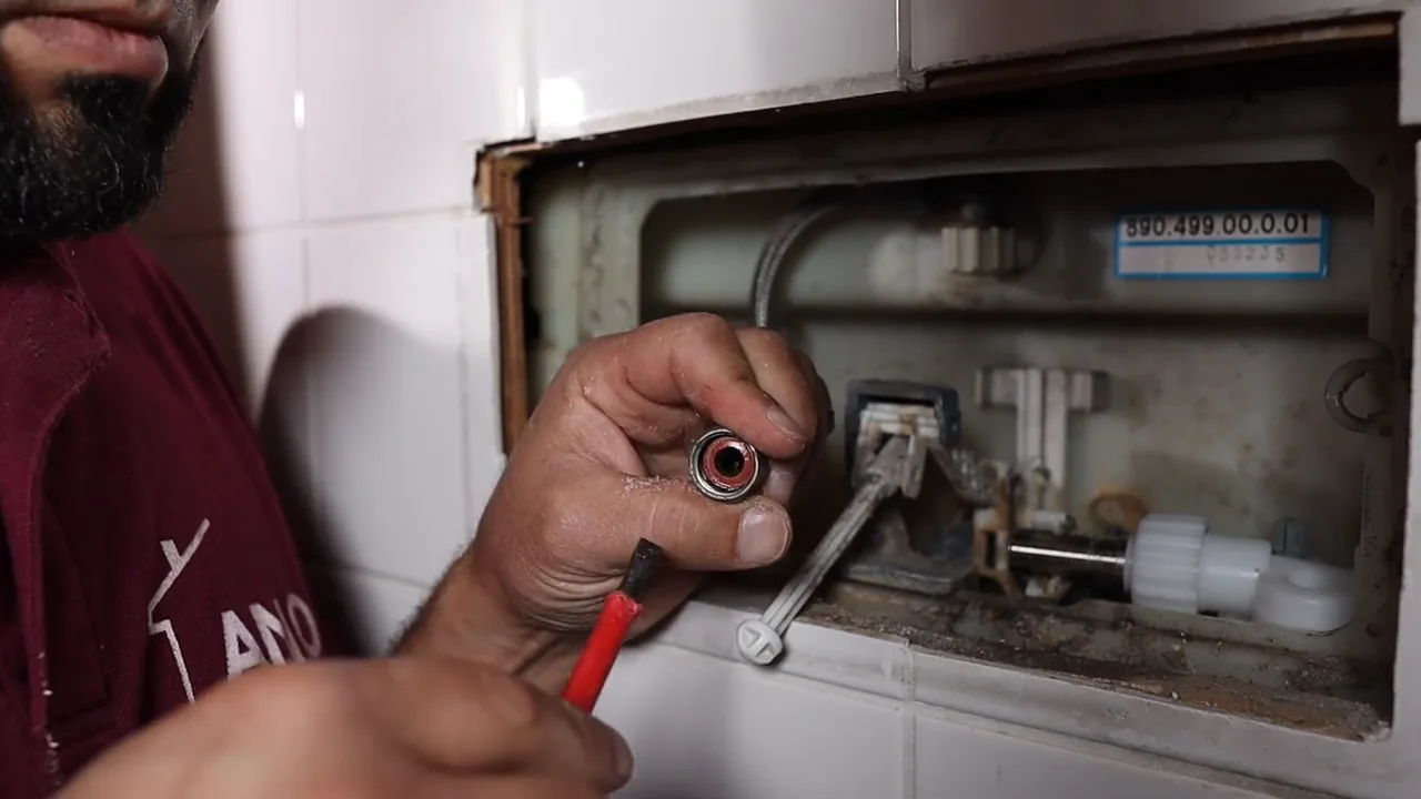 Hand toont de afdichting in de toevoerkoppeling van het reservoir