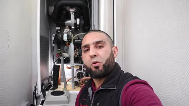 Anouar bij een geopende Remeha Calenta tijdens zijn lekkageonderzoek
