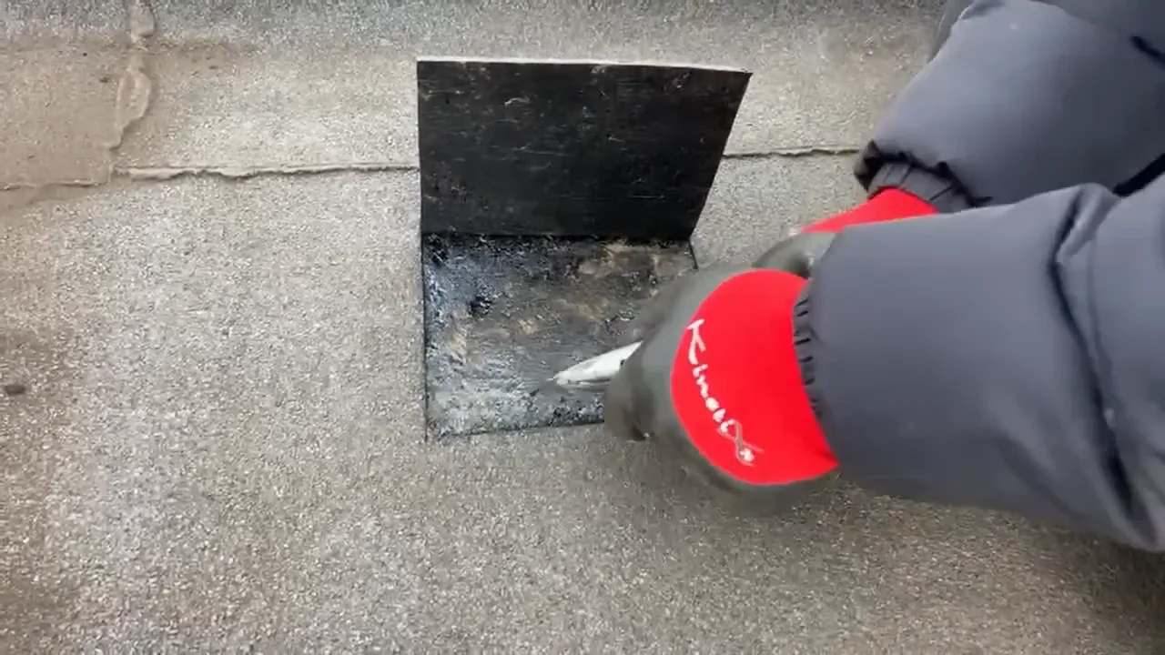Geopende inspectieflap met de oude laag onder de dakbedekking