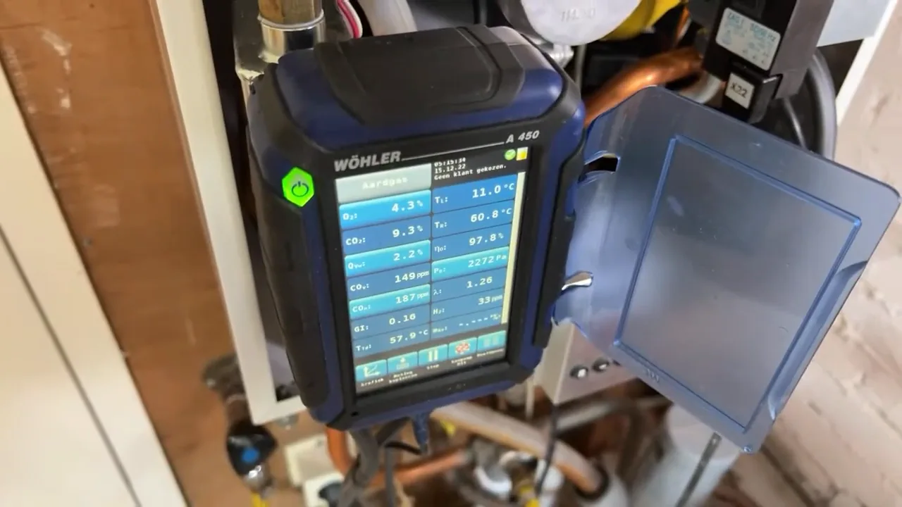 Rookgasanalyser bij de ketel met verschillende meetgegevens op het scherm
