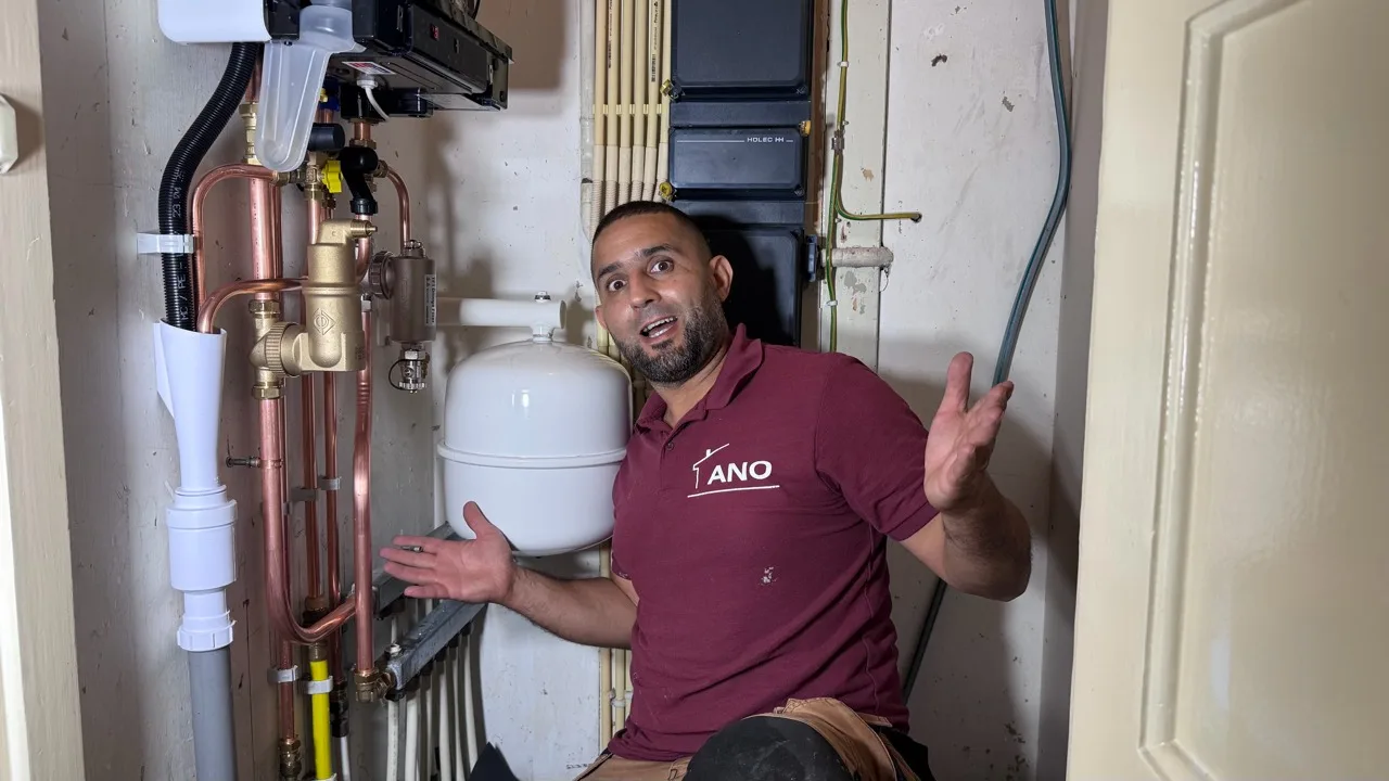 Loodgieter Anouar naast zorgvuldig aangelegd cv-leidingwerk