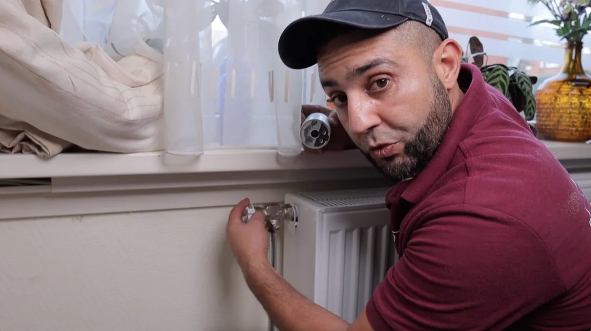 Anouar van ANO controleert de radiatorkraan bij een koude radiator