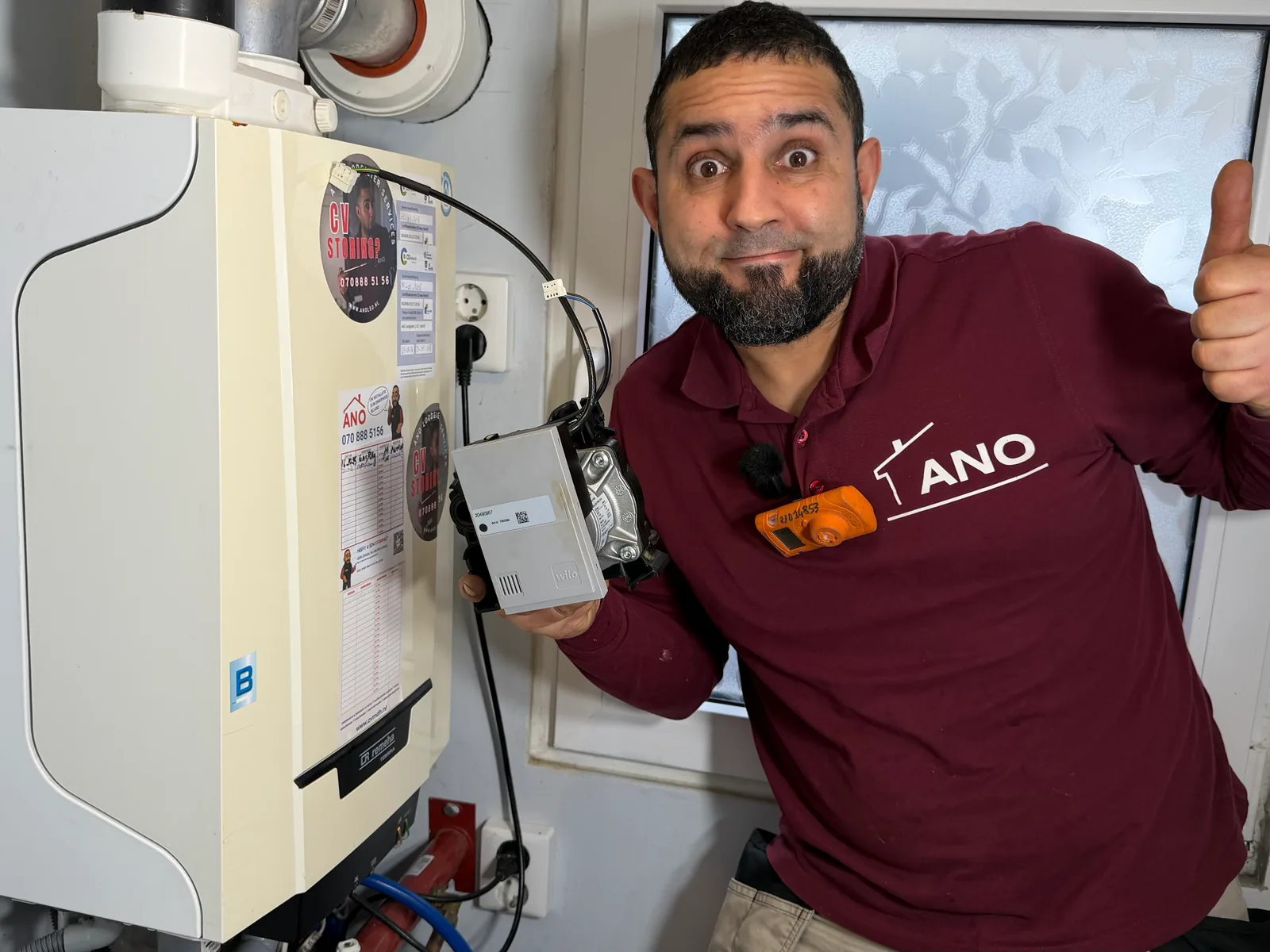 Anouar van ANO legt een cv-ketelonderdeel uit naast de installatie