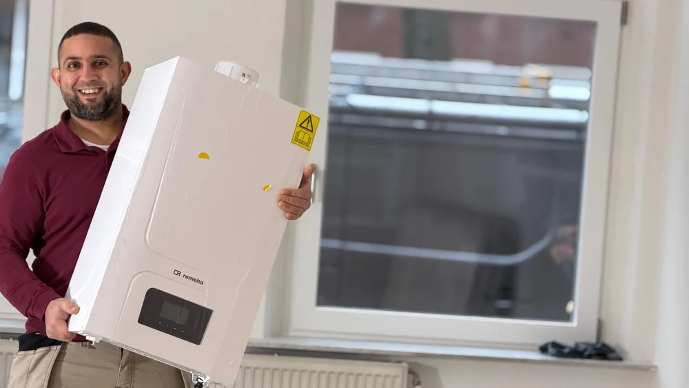 Loodgieter Anouar tilt een nieuwe Remeha-cv-ketel op tijdens installatiewerk