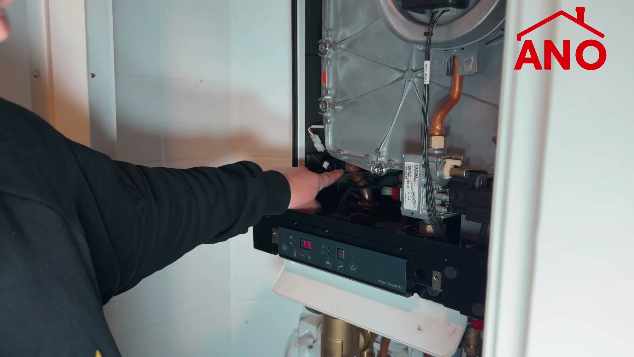 Anouar wijst de plek van de druksensor in de Intergas-ketel aan