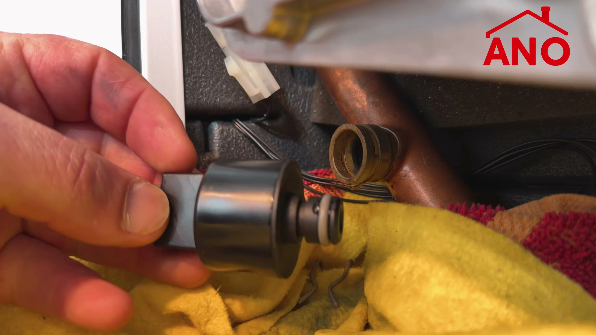 De vervangende druksensor in Anouars hand bij de aansluiting