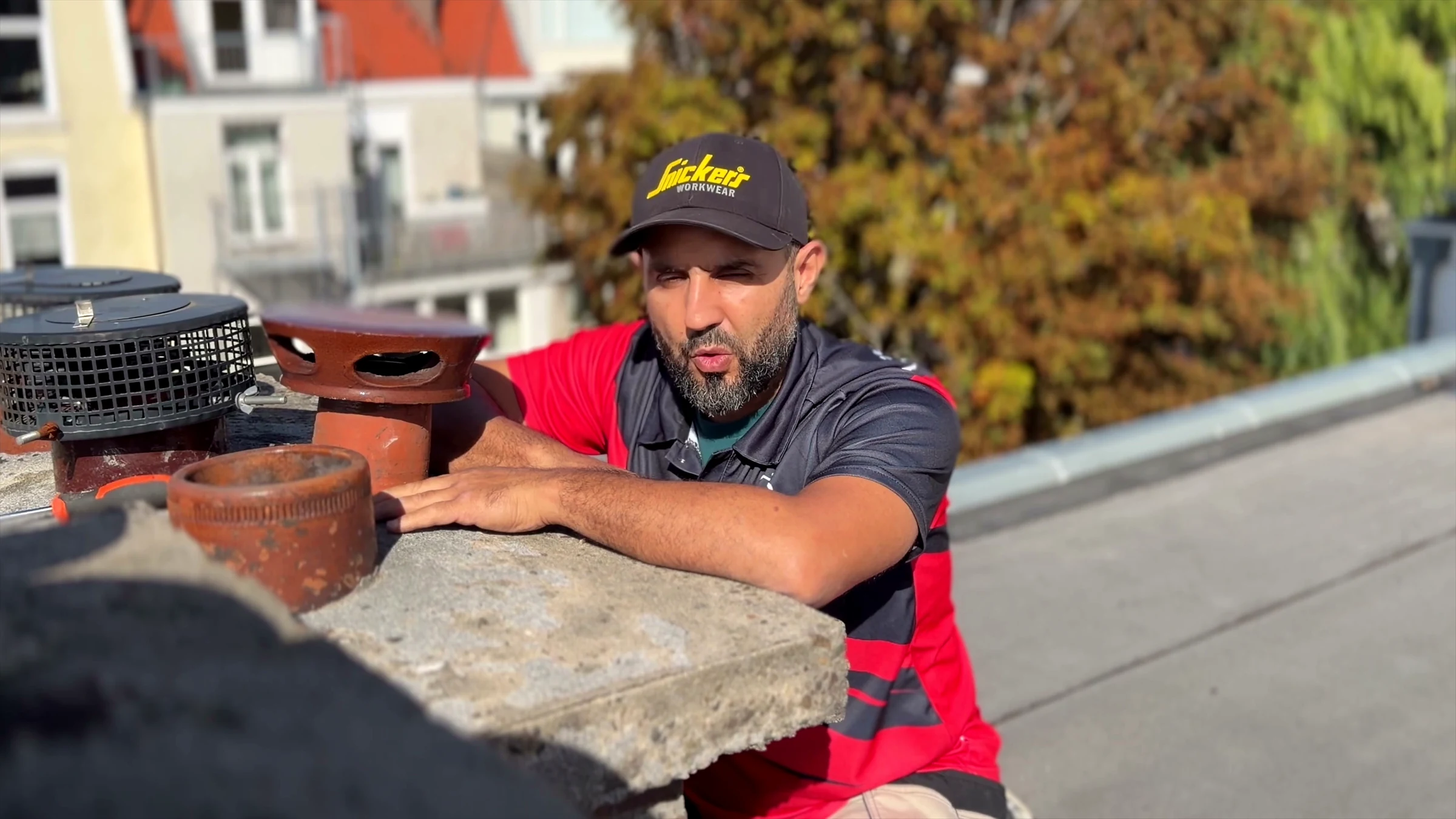 Anouar onderzoekt op het dak de uitmonding van de rookgasafvoer