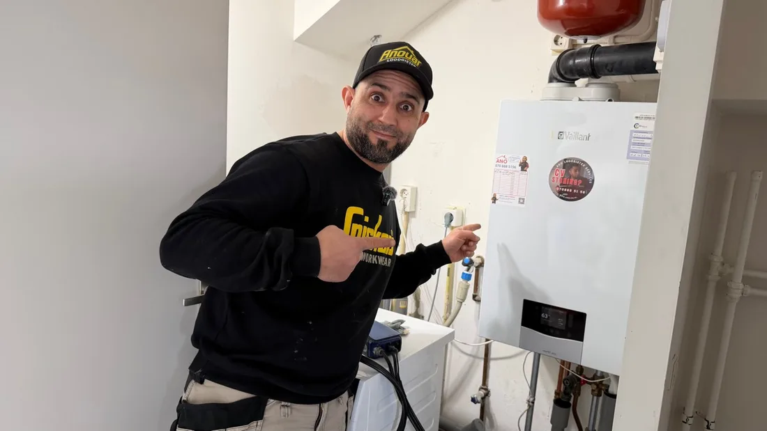 An ANO technician beside a central heating boiler