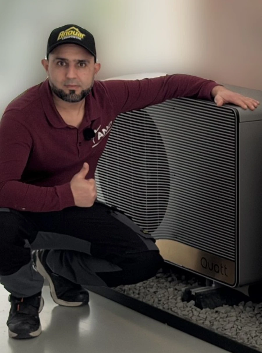 Anouar naast een warmtepompbuitenunit uit zijn eigen praktijk