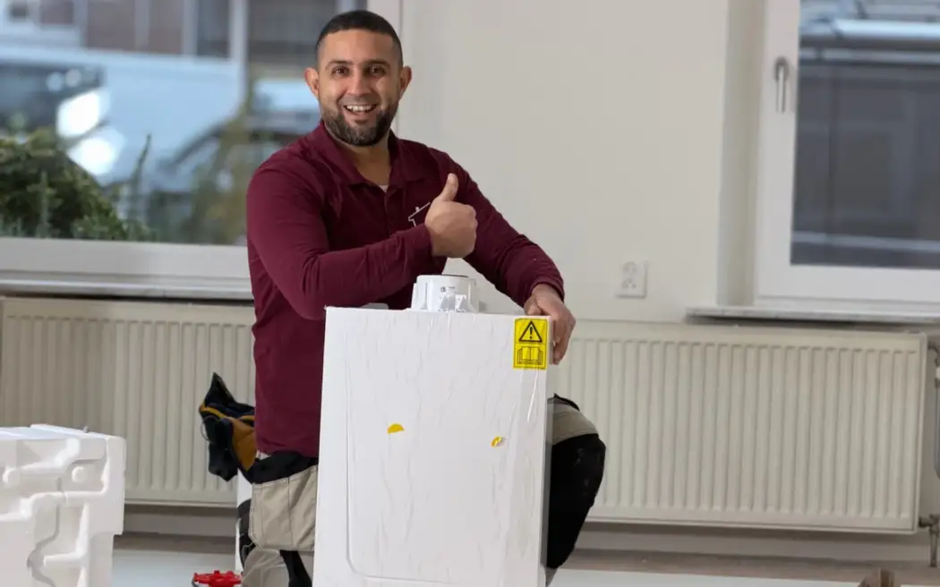 Anouar van ANO met een cv-ketel en radiatoren tijdens installatiewerk